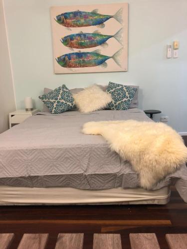 a bed with a white blanket and pillows on it at SEA-esta in Nelly Bay
