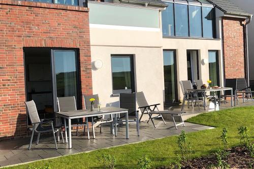a patio with tables and chairs next to a building at Tor zum Meer in Helgoland