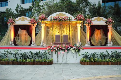 an outdoor altar with flowers and a stage at Rama Gardens Hotel Bangkok in Bangkok