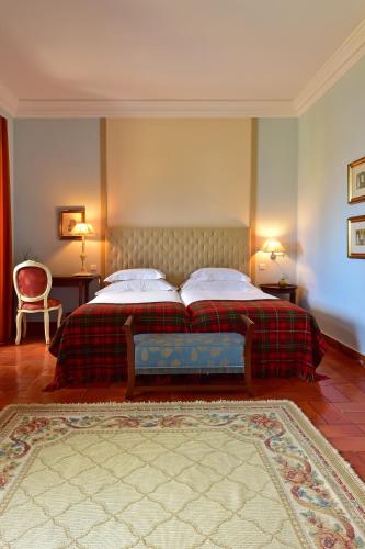 a bedroom with a bed and two lamps and a rug at Pousada Castelo de Palmela in Palmela