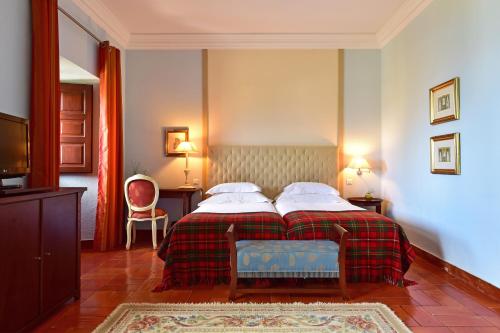 a hotel room with a bed and a chair at Pousada Castelo de Palmela in Palmela