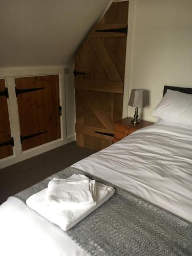 a white bed with a towel on it in a bedroom at Bishop Percys House in Bridgnorth