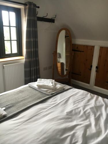 a bedroom with a bed and a mirror at Bishop Percys House in Bridgnorth