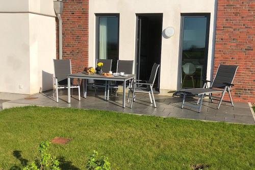 a table and chairs on a patio in a yard at Tor zum Meer in Helgoland