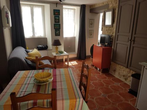 un salon avec une table et un canapé dans l'établissement Gite du Jardin Des Sources, à Vaux-sur-Seulles