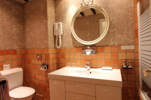 a bathroom with a sink and a mirror and a toilet at Hotel de la Bretonnerie in Paris