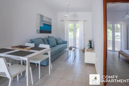 uma sala de estar com um sofá azul e uma mesa em Nikis Dream Comfy Apartments em Chania Town