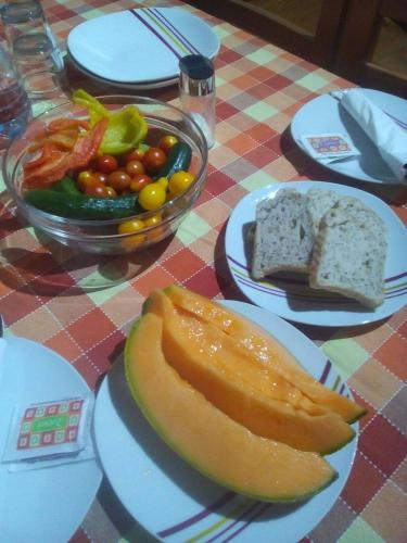 una mesa con un plato de comida y un tazón de verduras en Agriturismo La Farazzina, en Oleggio