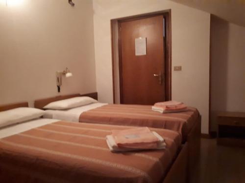 two beds in a hotel room with towels on them at La Colombella in Montemonaco