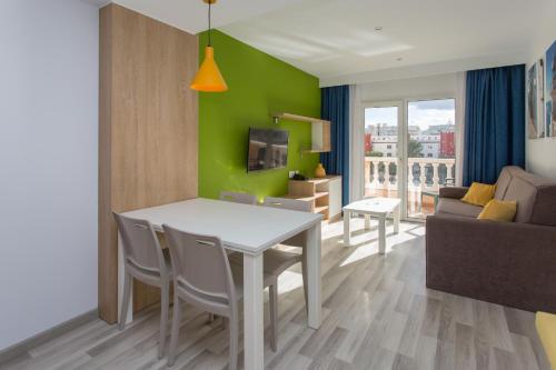 a kitchen and living room with a table and a couch at Aparthotel Acuasol in Peniscola