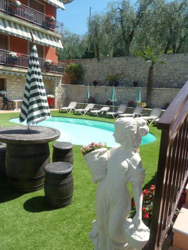a statue of an angel next to a swimming pool at Albergo Casa Este in Brenzone sul Garda