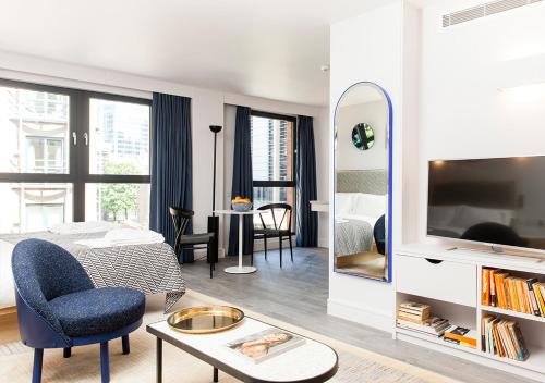 a living room with a bed and a room with a mirror at Rockwell East-Tower Bridge in London