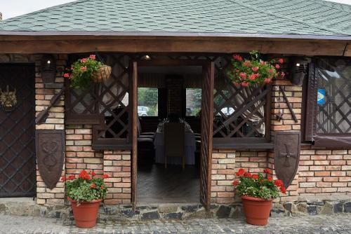 a pavilion with two potted plants and flowers at Aivengo Hotel in Rivne