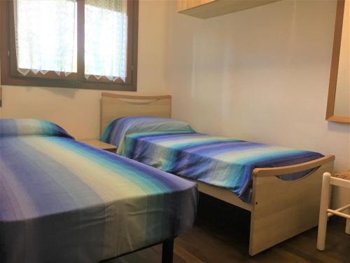 dwa łóżka pojedyncze w pokoju z oknem w obiekcie Villa Vittoria w Bibione