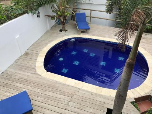 basen z palmą i niebieskimi krzesłami w obiekcie Hotel Palmera Beach Cartagena w mieście Cartagena de Indias