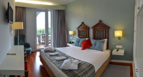 ein Hotelzimmer mit einem großen Bett mit Handtüchern darauf in der Unterkunft Hotel São Bento da Porta Aberta & Spa in Geres