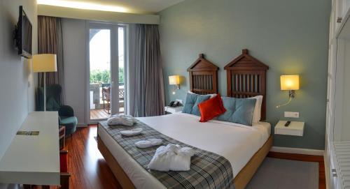 a hotel room with a large bed with towels on it at Hotel São Bento da Porta Aberta & Spa in Geres