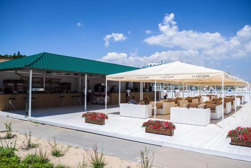 un pavillon avec des tables et des chaises sous une tente dans l'établissement Gold Bugaz Black Sea Hotel Group, à Gribovka