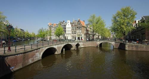 a bridge over a river in a city with buildings at Milkhouse Luxury Stay Amsterdam in Amsterdam