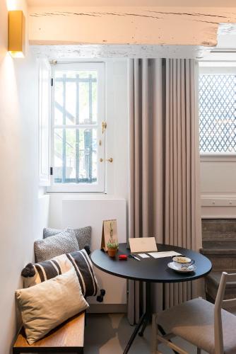a room with a table and a chair and a window at Milkhouse Luxury Stay Amsterdam in Amsterdam