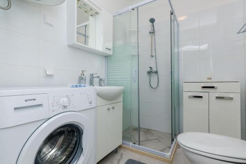 a white bathroom with a washing machine and a toilet at Guest House Nenada in Dubrovnik