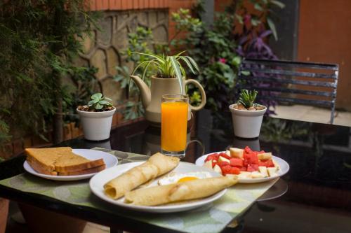 una mesa con dos platos de desayuno y un vaso de zumo de naranja en Hotel Atlantic, en Katmandú