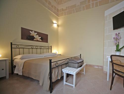 a bedroom with a bed and a chair and a tv at La Buona Creanza by Jdvacanze in Manduria