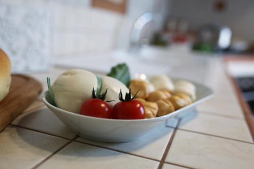 a bowl of tomatoes and other vegetables on a counter at La Buona Creanza by Jdvacanze in Manduria
