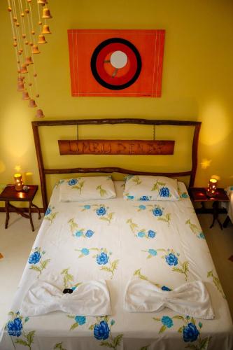 a bedroom with a bed with blue flowers on it at Pousada Umbudendê in Barra Grande
