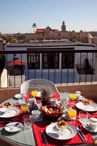 a table with food and orange juice on a balcony at Riad Charaï in Marrakech