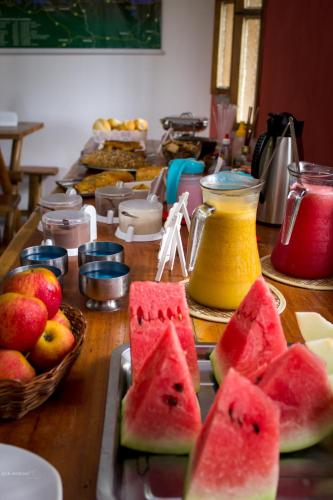 a table topped with slices of watermelon and other fruit at Pousada Umbudendê in Barra Grande