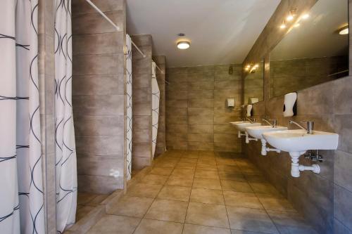 a bathroom with three sinks and two mirrors at Wioska Indiańska River Park in Zator