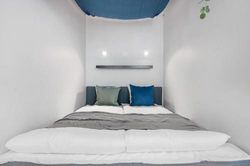 um quarto com uma cama grande e almofadas azuis em NG Apartments em Bergen