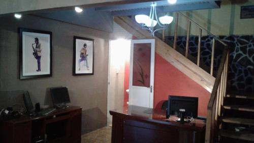 a room with a staircase and a desk with two monitors at Casa Grande Retiro para grupos in Cerro Azul