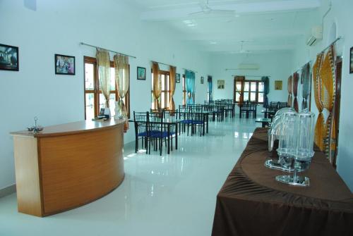 uma grande sala com mesas e cadeiras e um bar em Hotel isabel Palace em Khajuraho