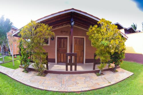 a small house with a table in the front yard at Pousada Villa Da Montanha in São Bento do Sapucaí
