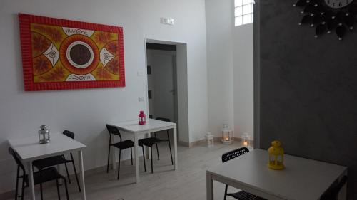 two tables and chairs in a room with a painting on the wall at Marselo B&B in Bari