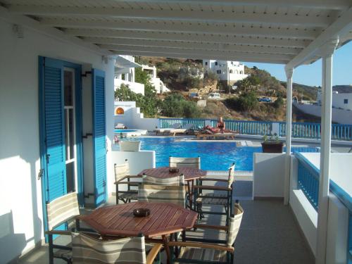 a patio with a table and chairs and a swimming pool at Golden Sun in Ios Chora