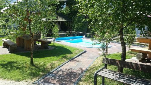 a park with a bench and a swimming pool at Willa Pod Dębami in Rabka-Zdrój