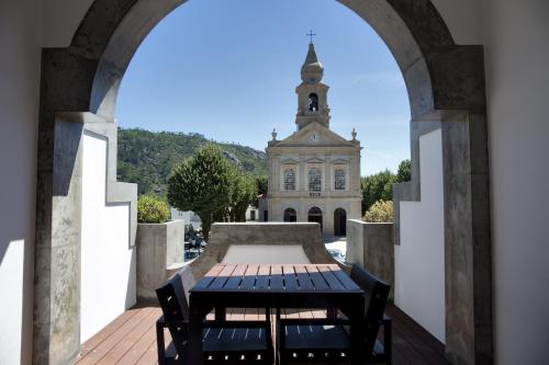 an archway with a table in front of a church at Hotel São Bento da Porta Aberta & Spa in Geres