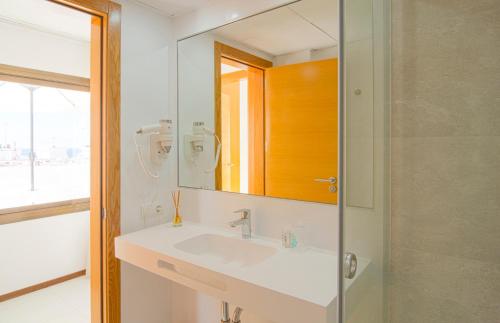 a bathroom with a sink and a mirror at Apartamentos Bon Lloc in Santa Eularia des Riu