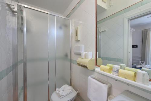 a bathroom with a shower and a toilet and a mirror at Hotel7Bello in Minori