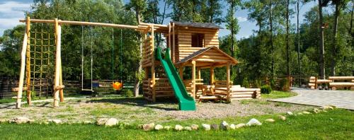 a playground with a green slide and a log cabin at Pension Pîrîu' Morii in Gura Humorului