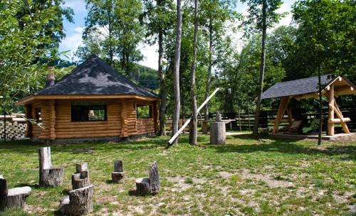 a log cabin with a playground in front of it at Pension Pîrîu' Morii in Gura Humorului
