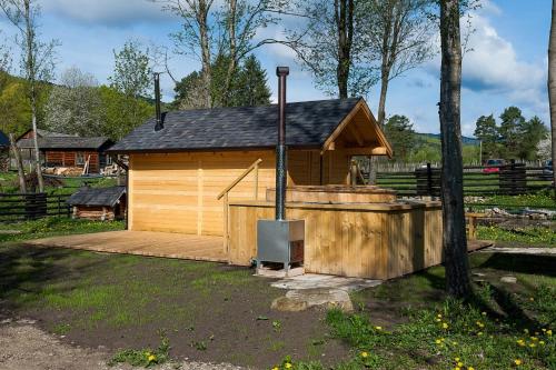 a large wooden building with a stove in front of it at Pension Pîrîu' Morii in Gura Humorului