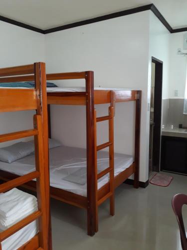 a room with three bunk beds in a room at Gardenview Homestay Siargao in General Luna
