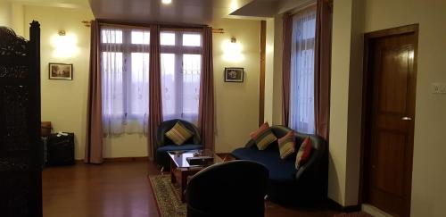 sala de estar con 2 sillas y ventana en Woodland Hill Stay, en Shillong