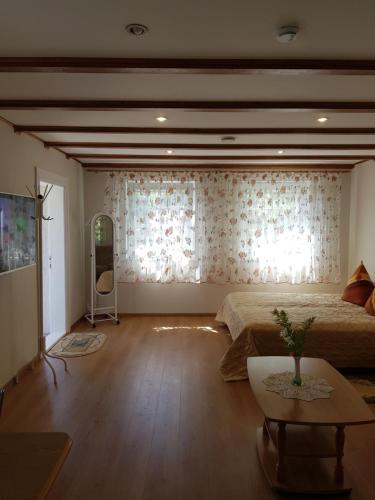 a bedroom with two beds and a table and a television at Namelis Nidoje in Nida