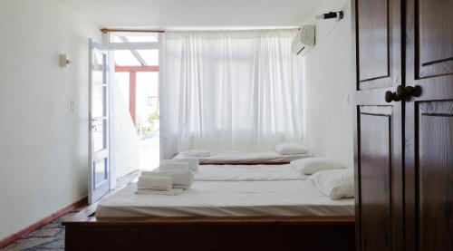 two beds in a room with a window at ''The Boulas'' Rooms in Megalochori