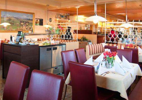 Rainbach im MühlkreisにあるHotel Blumauerのテーブルと椅子とキッチンのあるレストラン